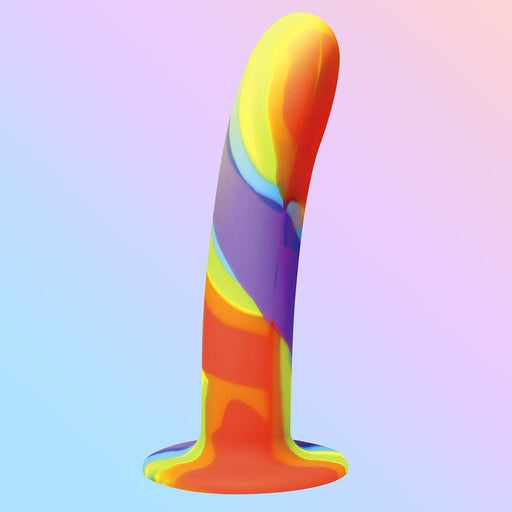 The Simply Sweet 7" Rainbow Silicone Dildo by Curve Toys is a phallic-shaped silicone dildo with a strong suction cup and flared base. It features a smooth surface adorned with vibrant swirled patterns in red, yellow, green, blue, and purple set against a pastel gradient background.