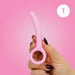 A hand with dark nail polish holds a Skins Care Curved Vaginal Dilator (Small), made of pink medical-grade silicone with a rounded ring handle, against a pink backdrop with a white "1," supporting pelvic health. Part of 3-piece set (Small/Medium).
