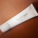 A white tube of "Bijoux Indiscrets Slow Sex Finger Play Gel for Fingering," with a hint of coconut aroma, rests on a surface. The 30 ml (1 fl oz) tube offers natural lubrication perfect for enhancing your intimate moments.