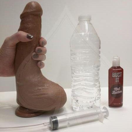 Squirting Realistic Cock Tan 9.2 Inches with a hand holding the dildo next to a standard water bottle to show size