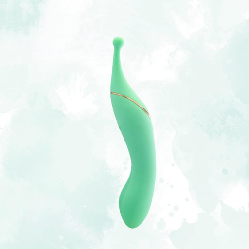 The Stella Double Ended G-Spot & Clitoral Vibrator is a teal, sleek silicone massager with gold accents and a curved double-ended design, displayed on a soft pale green and white background.