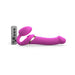 The Strap-on-Me Multi Orgasm Bendable Strap-on with Clitoral Tongue - Large by Lovely Planet, featuring an ergonomically-shaped clitoral stimulator with a curved design, is placed next to a slim rectangular remote control. The remote includes multiple buttons such as plus and minus symbols and a power button, indicating adjustable settings.