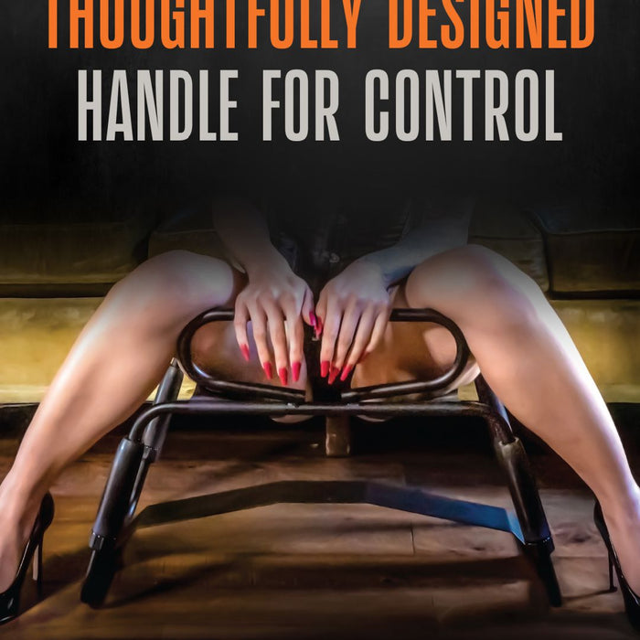 A person with red-painted nails holds onto a handle while sitting on the Surrender Sex Chair with 8 Inch Vibrating Dildo. Text above reads "Thoughtfully Designed Handle for Control." The room has subdued lighting, focusing attention on the hands and the handle. The product is by blush.