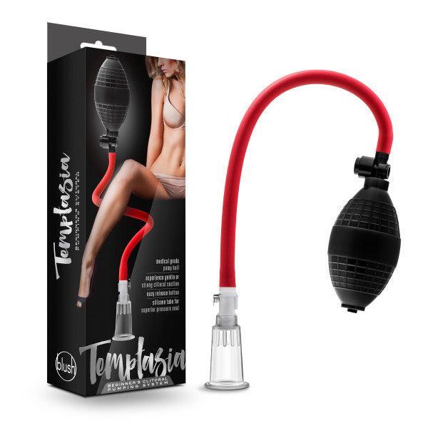 Box and product of the Temptasia Beginner's Breast and Clitoral Pumping System by Blush, featuring a clear suction cup connected to a black and red pump with a flexible hose for enhanced pleasure. Packaging includes an image of a person in lingerie.