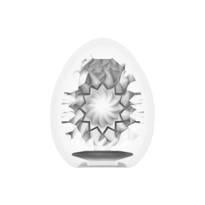A white, spherical sculpture from the Tenga Egg Disposable Penis Masturbator - Shiny 2 with a symmetrical geometric cut-out pattern creating an illusion of depth, set against a plain backdrop.