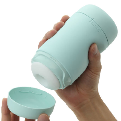 A hand is holding a cylindrical teal cup with a white interior. Another hand is removing the detachable lid from the bottom of the cup, which has a silicone cover for easy cleaning and maintenance. The Tenga Puffy Discreet Ultra Soft Beaded Masturbator - Mint Green and lid both have a smooth, matte finish.