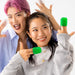 Two young adults joyfully playing with Tenga Uni Topaz Textured Finger Sleeve for Stroking and Clit Massage and plastic containers, one with pink hair and blue shirt, the other in a gray sweater. They are both smiling at the camera, enjoying a discreet moment.