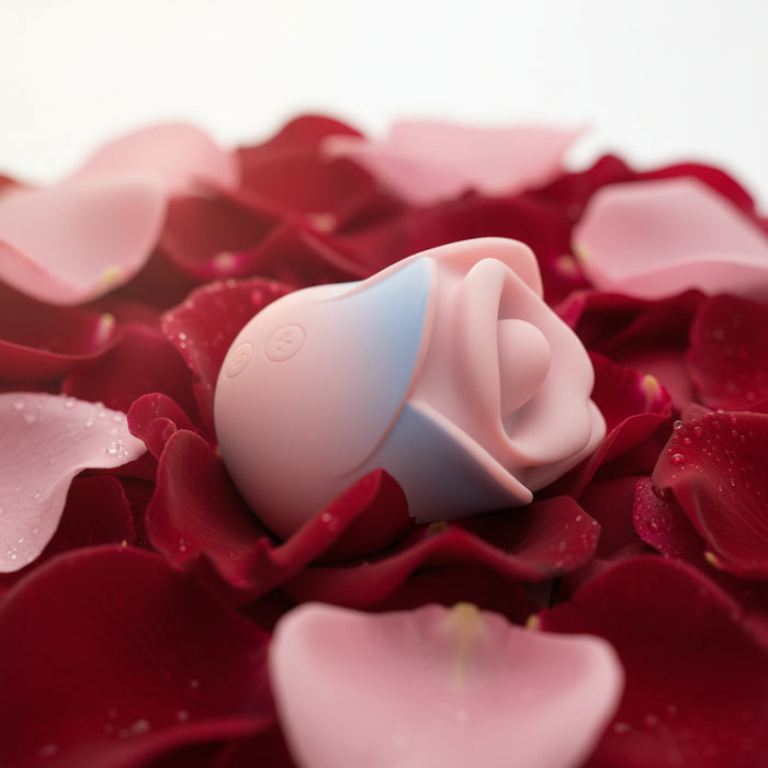 The Kissing Rose Vibrator with Tongue and Lips, in pink and light blue body-safe silicone, features a rose shape with petal-like edges and visible control buttons, shown against a white background.