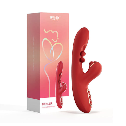 A red Tickler Wiggling G-Spot Vibrator & Tapping Clitoral Stimulator stands upright beside its pink-peach gradient "Honey Play Box" packaging, designed for powerful G-spot and clitoral pleasure.