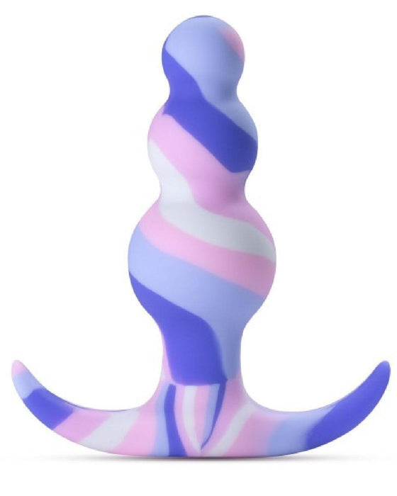 The image showcases the Twilight Beginner Purple and Pink Silicone Butt Plug by Blush, featuring a swirled design in pastel colors. The toy has a bulbous shape with three rounded sections and a curved, T-shaped base for easy handling and safety, making it ideal for anal beginners.