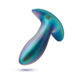 Introducing the Voyager Smooth Vibrating Butt Plug & Prostate Massager by Blush, featuring a sleek metallic and iridescent design with a smooth, bulbous shape and a flared base. Crafted from stunning silicone, its surface beautifully reflects shades of blue, green, and purple. This exquisite piece is showcased against a crisp white background.