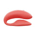 The We-Vibe Chorus Remote & App Controlled Couples' Vibrator in Coral is a red, curved silicone toy with two parallel, rounded ends—one larger and one smaller—designed for an adjustable fit and modern look.