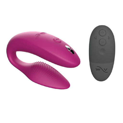 A We-Vibe Sync Remote and App Controlled Wearable Couples Vibrator in Dusty Pink, along with a black remote control featuring multiple function buttons, are shown. The We-Vibe couples' vibrator showcases a sleek, curved design with textured ridges on one end, while the remote boasts a simple and ergonomic design.