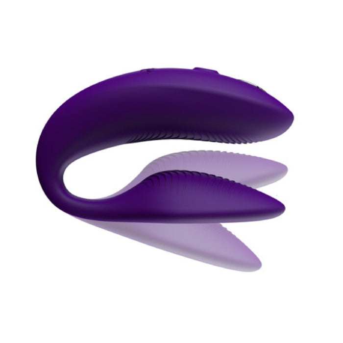 A purple, U-shaped wearable device with soft, ribbed arms is positioned against a plain white background. The sleek design and curved shape suggest it might be the We-Vibe Sync Remote and App Controlled Wearable Couples Vibrator by We-Vibe, aimed at enhancing personal wellness.