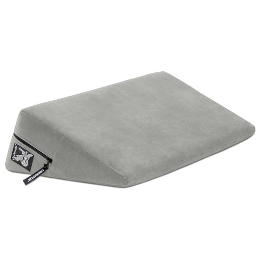 The Liberator Wedge 24 Inches is a gray, wedge-shaped sex pillow with a soft cover, visible zipper, and small side tag—designed to provide enhanced comfort and deeper angles during intimacy.