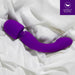 The Wellness Dual Sense Double Ended Ergonomic Waterproof Wand in vibrant purple silicone lies gracefully on a white satin fabric, with a logo in the top right corner indicating "UltraSilk™ Silicone" from Blush.