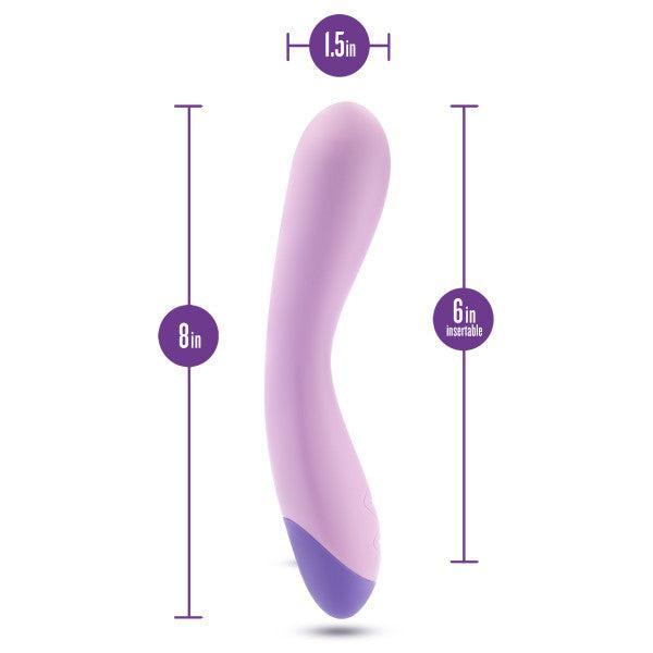 Introducing the Wellness G Curve Rumbly Waterproof Silicone G-Spot Vibrator by Blush—a lavender-colored vibrator specially designed with a slight curve. Crafted from silky silicone, it measures 8 inches in total length, with a 6-inch insertable length and a diameter of 1.5 inches at its widest point. Perfect for G-spot exploration, its base is adorned in a darker purple shade.

