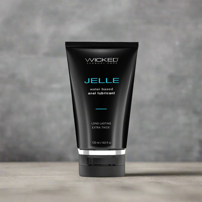 A black cylindrical tube labeled "Wicked Anal Jelle Water Based Lubricant 4 oz" by Wicked Lubes stands upright against a white background. The packaging also states "Long Lasting Extra Thick" and confirms that this 120 ml (4.0 fl oz) product is sex toy friendly.