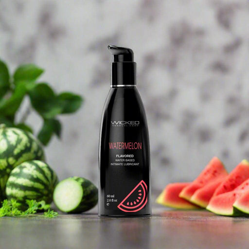 A bottle of Wicked Aqua Watermelon Flavored Water Based Lubricant 2 oz from Wicked Lubes is shown. The paraben-free lube features a pump dispenser and a red watermelon slice graphic. It contains 60 ml (2 fl. oz.) of product.