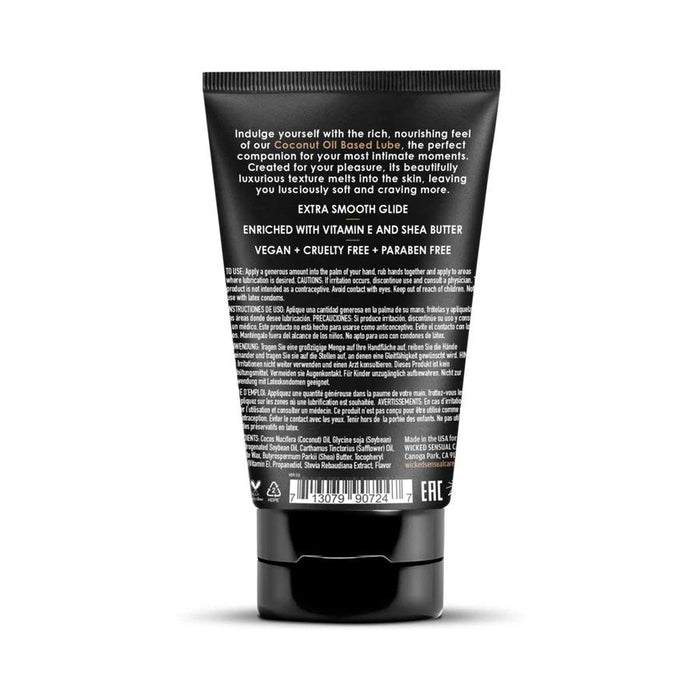 A black tube of Wicked Coconut Oil Based Lubricant - 4 oz stands upright, showing its back label with white text listing ingredients, usage instructions, and benefits like vitamin E and shea butter for gentle intimate care.