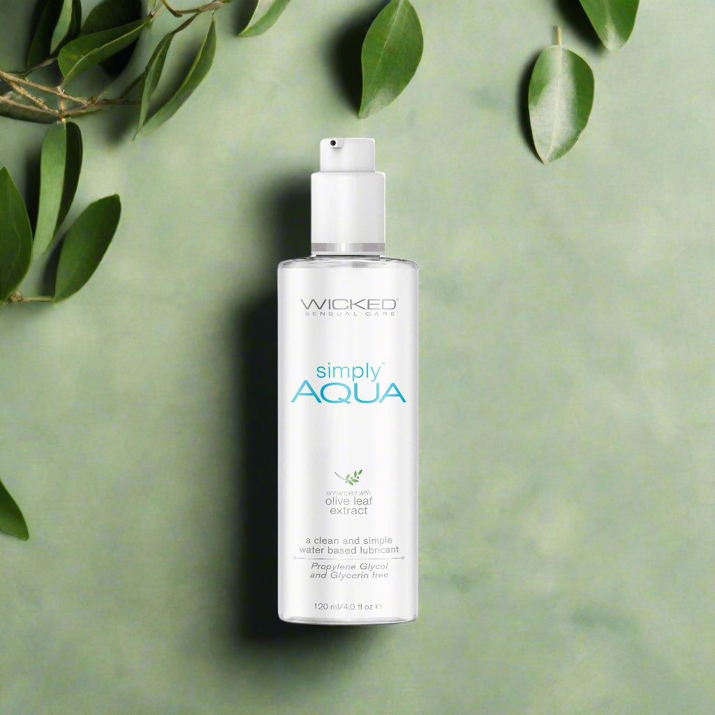 A clear plastic bottle with a pump dispenser labeled "Wicked Simply Aqua Water Based Lubricant 4 oz" from Wicked Lubes, featuring olive leaf extract. The 120 ml (4.0 fl oz) bottle contains a clean, simple, cruelty-free, water-based lubricant that is free from propylene glycol and glycerin.