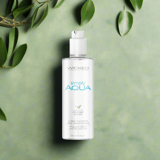 A clear plastic bottle with a pump dispenser labeled "Wicked Simply Aqua Water Based Lubricant 4 oz" from Wicked Lubes, featuring olive leaf extract. The 120 ml (4.0 fl oz) bottle contains a clean, simple, cruelty-free, water-based lubricant that is free from propylene glycol and glycerin.