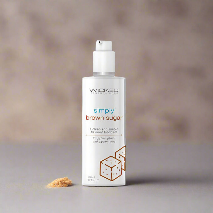 A 4 oz bottle of Wicked Lubes' "Wicked Simply Brown Sugar Flavored Water Based Lubricant" in white, featuring a white label with brown text that reads "a clean and simple flavored lubricant." This product is free from propylene glycol and glycerin, water-based, pH balanced, and comes with a pump dispenser.