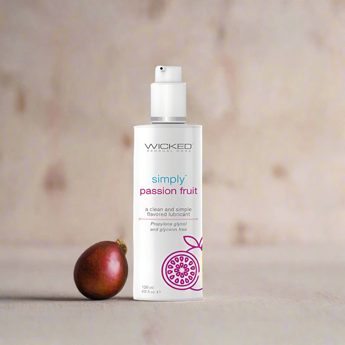 The "Wicked Simply Passion Fruit Flavored Water Based Lubricant 4 oz" by Wicked Lubes is presented in a white bottle adorned with a sketch of a passion fruit at the bottom, promoting its clean and simple passion fruit flavor. This water-based lubricant features a propylene glycol and glycerin-free, pH-balanced formula, and includes a convenient pump dispenser for easy use.