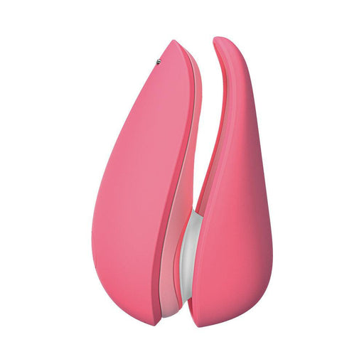 The Womanizer Liberty 2 is a pink, petal-shaped silicone travel stimulator with two curved sides, shown upright on a white background. This waterproof device offers discreet clitoral pleasure anytime, anywhere.