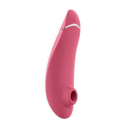 The Womanizer Premium 2 Pleasure Air Clitoral Stimulator in Raspberry, by Womanizer, is a pink, ergonomically shaped personal massager with a smooth surface and a small opening at its tip. Its sleek design features a white accent line near the top, indicating a potential button or control feature for its air pulsation stimulator.
