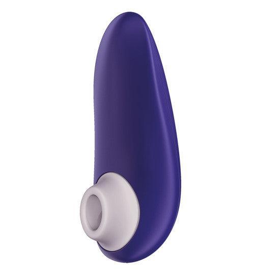 Introducing the Womanizer Starlet 3 Pleasure Air Clitoral Stimulator in Indigo. This sleek personal massager features a dark purple hue, a curved design, and a white silicone tip. With USB rechargeable capabilities for convenience, this device boasts a streamlined appearance for ergonomic handling and precise use, delivering enhanced clitoral stimulation.