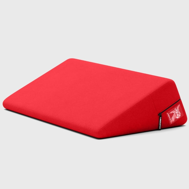 The Liberator Wedge Sex Positioning Cushion - 30 Inches is a red, wedge-shaped pillow made of high-density foam with a zippered cover and small logo tag, shown on a light grey background.