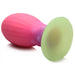 This image features the Xeno Egg Glow In The Dark Silicone Egg by XR Brands, a squishy and flexible butt plug with a textured pink bulb and a wide, flat green base. The toy is designed with ridges for added sensation and boasts a stunning color gradient from pink to green.