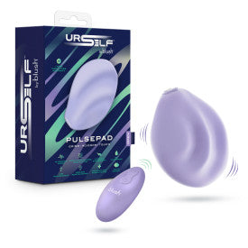 The Pulse Pad Squishy Silicone External Vibrator with Remote, shown in lavender alongside its matching remote, is displayed next to packaging featuring “URSELF PULSEPAD” branding and a modern geometric design in dark blue, green, and purple.