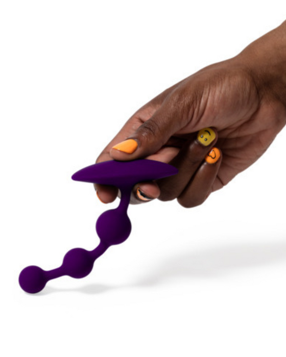 Romp Amp Flexible Anal Beads being held by a hand upside down to show its flexibility - on a white background 