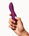 Dame Dip Beginner's  Internal & External Silicone Vibrator - Plum being held by a hand on a white background