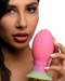 Xeno Egg Glow In The Dark Silicone Egg being held by a model on a white background
