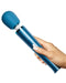 A hand holding a Le Wand Petite Massager - Blue, made of body-safe silicone, against a white background.