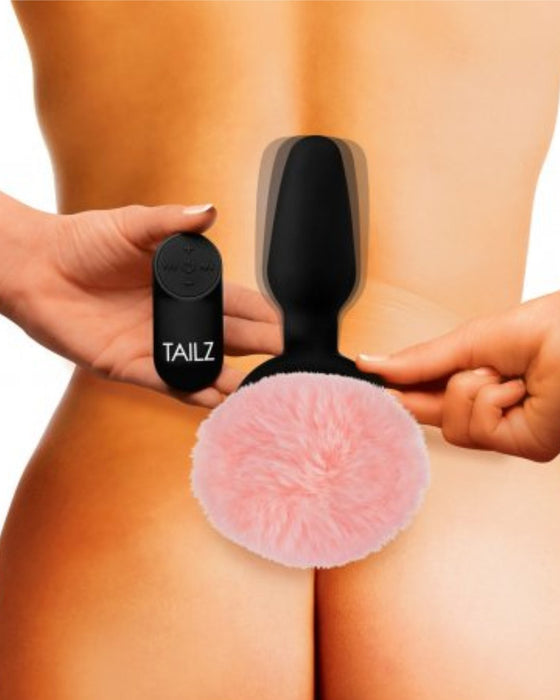 Tailz Pink Bunny Tail Vibrating Anal Plug model holding it 