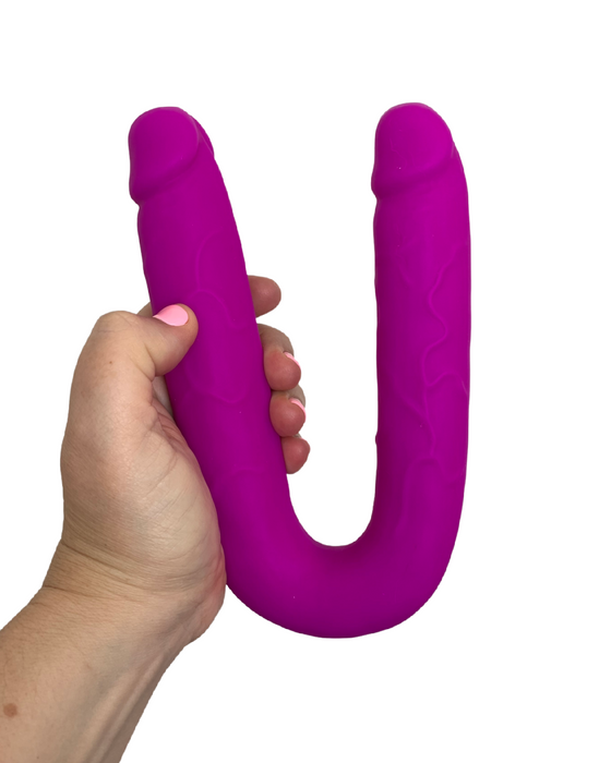Colours Double Penetration U Shaped Dildo - Purple held in a hand on a white background