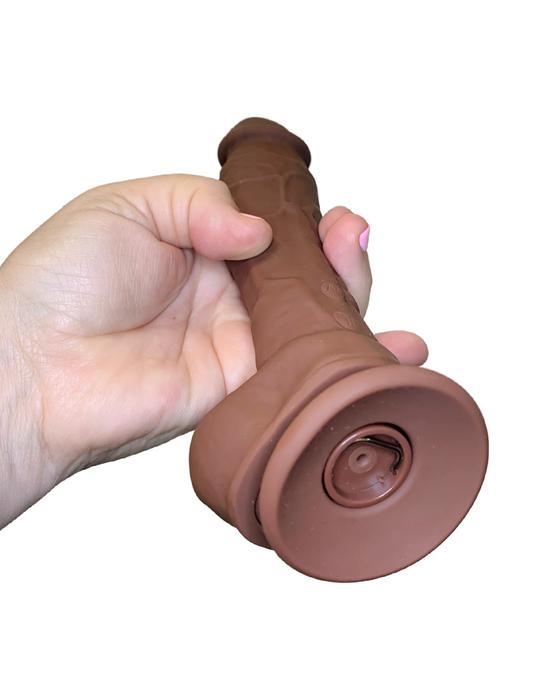 Betty's Blaster 8 Inch Vibrating Squirting Silicone Dildo - Chocolate held in a hand