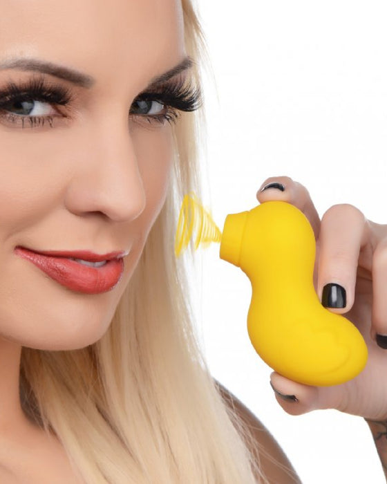 Sucky Ducky Silicone Clitoral Sucker - Yellow held in a blonde woman's hand next to her smiling face