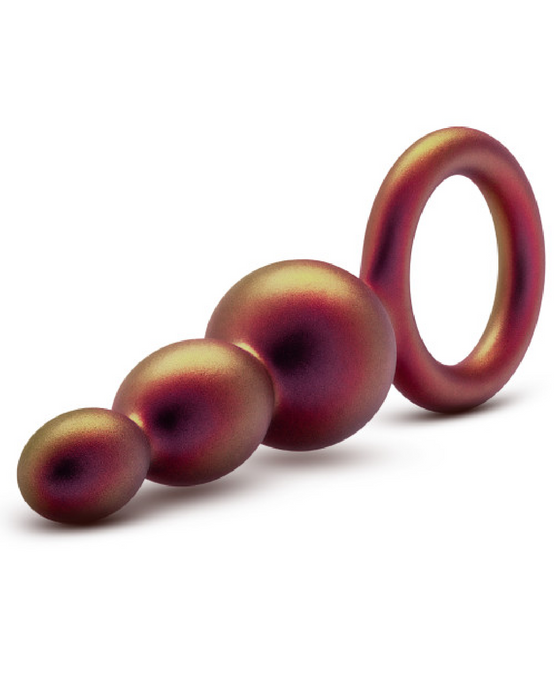 Four Matrix First Time Soft Silicone Beaded Anal Beads with Finger Loop in a purple and red gradient decreasing in size connected in a line with the largest sphere attached to a ring with a similar color scheme, all against a white background.