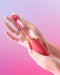 Ella Neo Interactive App Controlled Wearable Egg Vibrator held in hand on pink background