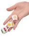 A hand holding three Emojigasm Dice Game for Lovers from CalExotics, with various colorful emoji faces and symbols on the sides, including a smiley face, a thumbs-up icon, an ear.