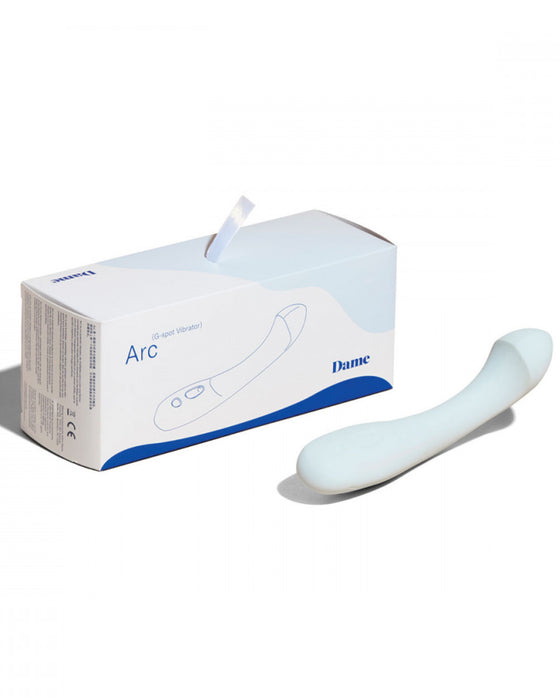Dame Arc Silicone Waterproof G-Spot Vibrator  with its box against a white background