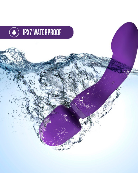 A purple Wellness Dual Sense Double Ended Ergonomic Wand, crafted from body safe silicone, partially submerged in water, demonstrating its ipx7 waterproof rating, with dynamic water splashes around it. The text "ipx7 waterproof" is.