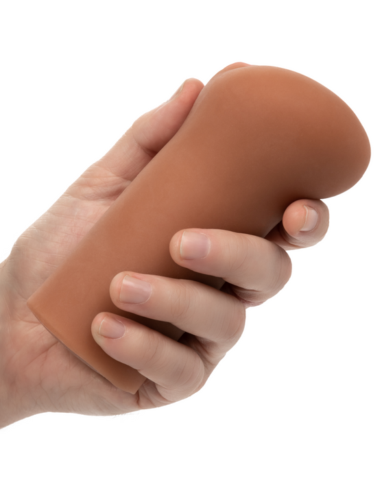 Boundless Vulva Styled Penis Stroker - Mocha held in a person's hand