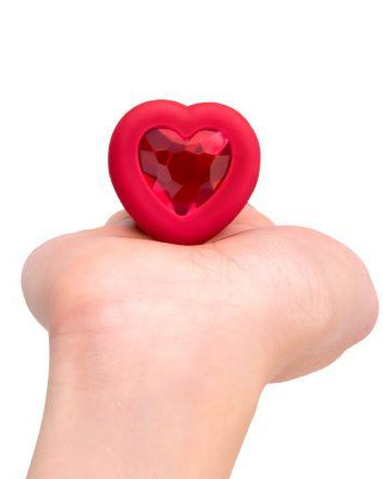 B-vibe Vibrating Heart Shaped Jewel Anal Plug M/L - Red showing gem bottom in model's hand 