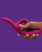 A hand holding a pink We-Vibe Nova 2 Powerful Flexible G-Spot Rabbit Vibrator against a purple background.